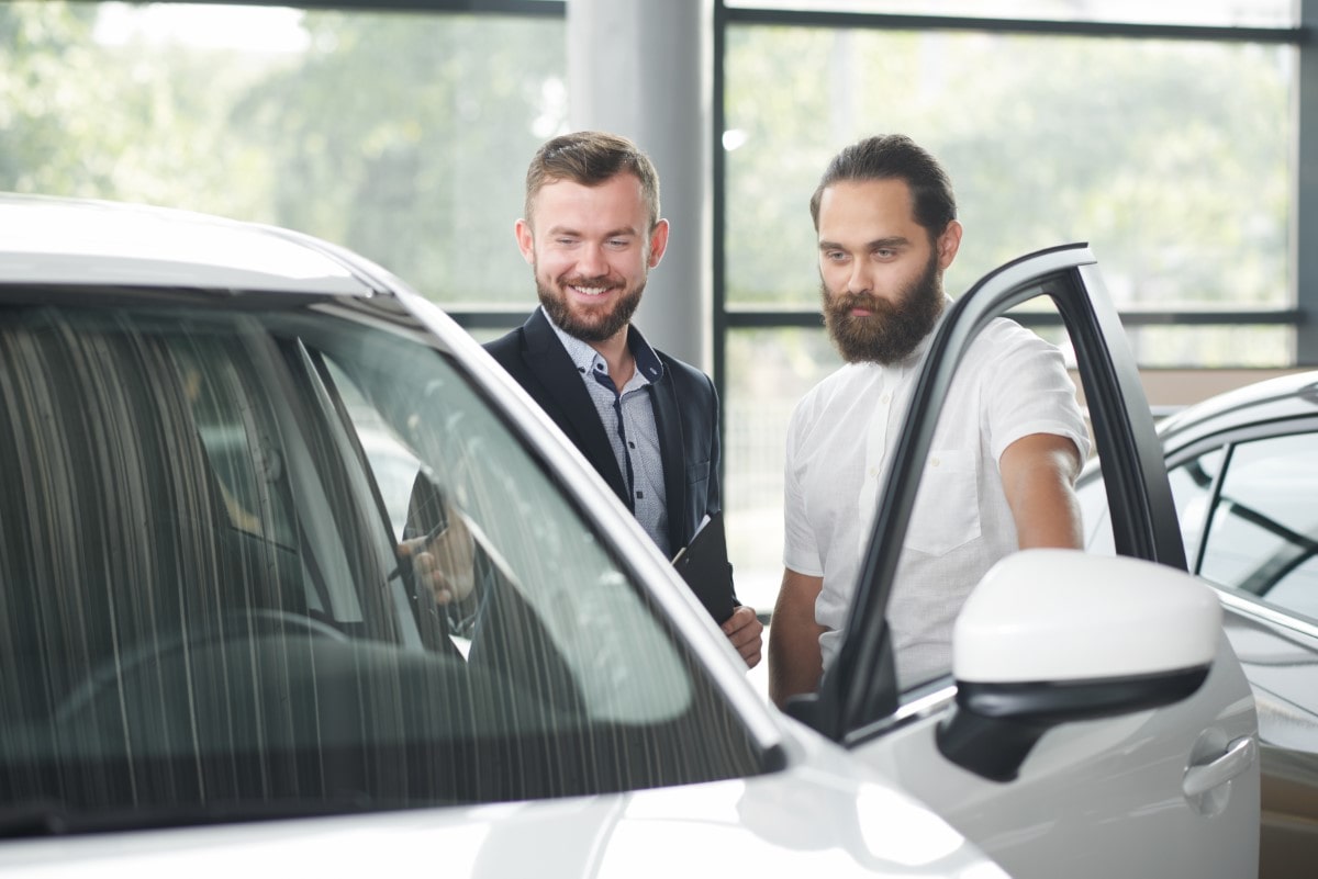 client-car-dealership-observing-car-with-manager-min